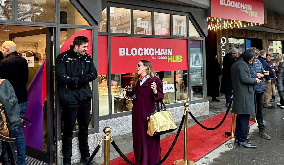 A woman chats happily with a security guard in front of the entrance