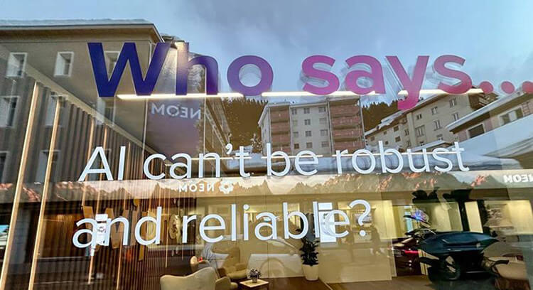 Image of Davos event - Who Say AI can't be robust and reliable? white text on window