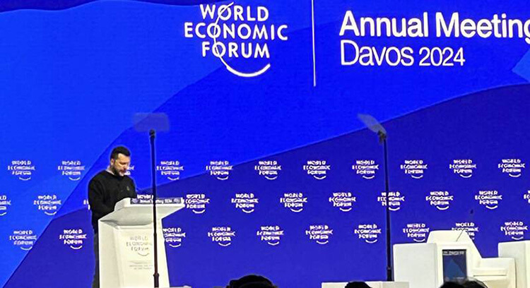Image of Davos event - Presenter at podium with World Economic Forum Annual Davos in the background