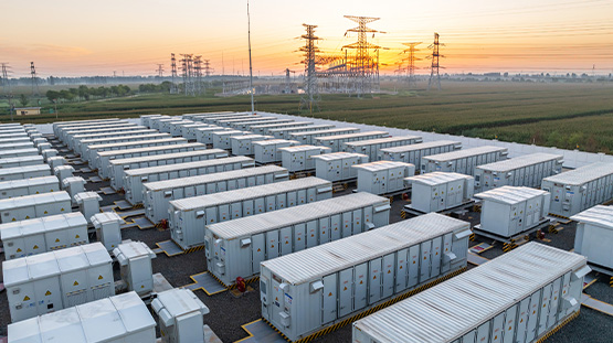 Image of battery storage containers in a lot with a sunset